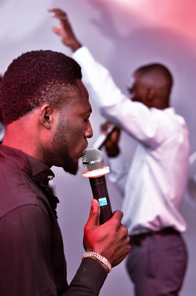 Two men in a religious setting holding microphones and praising.