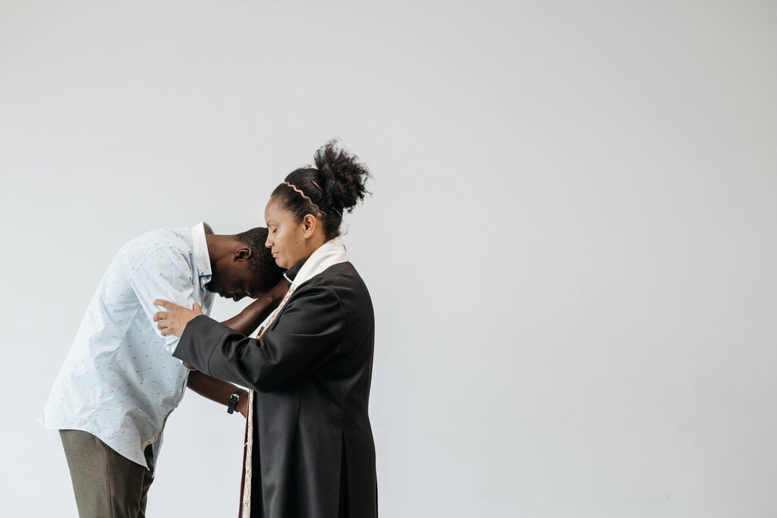 A pastor and parishioner in an intimate prayer moment, symbolizing faith and support.